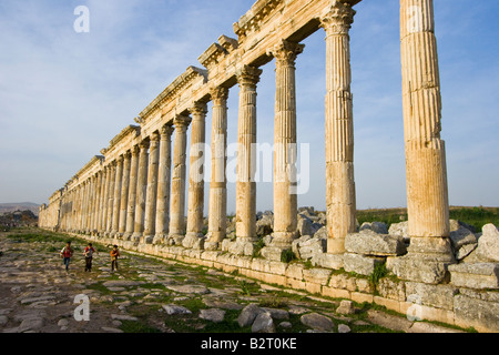 Ragazzi locali e la Collonade presso le rovine Romane di Apamea in Siria Foto Stock