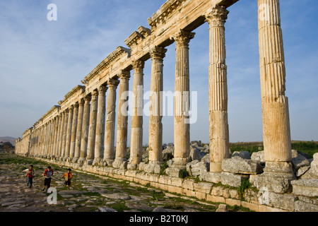 Ragazzi locali e la Collonade presso le rovine Romane di Apamea in Siria Foto Stock