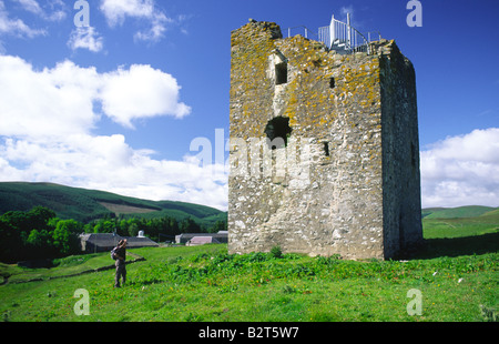 Walker sul Southern Upland Way in piedi accanto al XVI centuary ruderi della Torre Dryhope in Scottish Borders Scotland Regno Unito Foto Stock