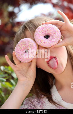 Ragazza adolescente giocando con le ciambelle Modello rilasciato Foto Stock