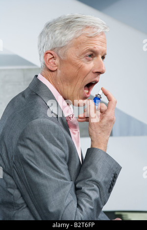 Uomo che utilizza mouthspray Foto Stock