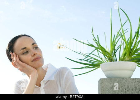 Donna contemplando impianto Foto Stock