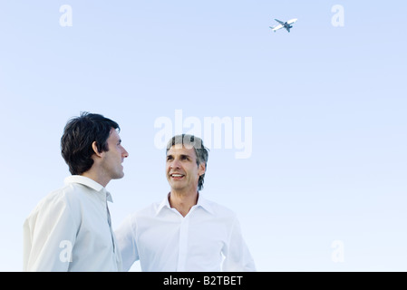 Conversazione tra due uomini per ogni altro aereo alta in background Foto Stock