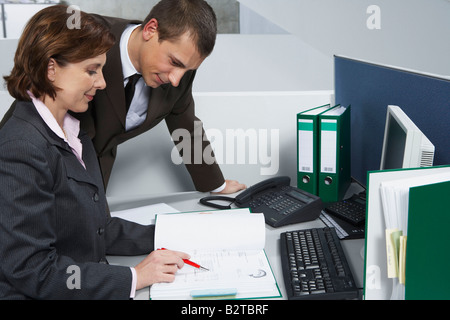 I colleghi guardando il documento Foto Stock