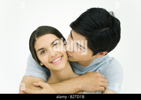 Giovane donna bacio sulla guancia, Donna sorridente in telecamera Foto Stock
