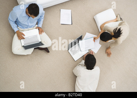 Business Associates seduti insieme sul pavimento, utilizzando computer portatili, vista aerea Foto Stock