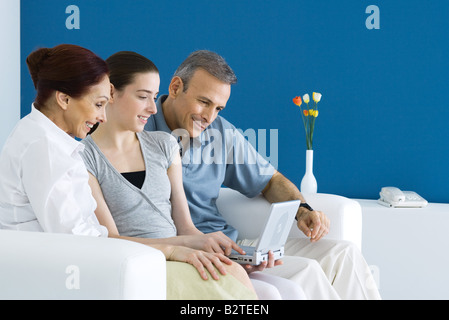 Famiglia guardare lettore DVD portatile insieme sul divano Foto Stock