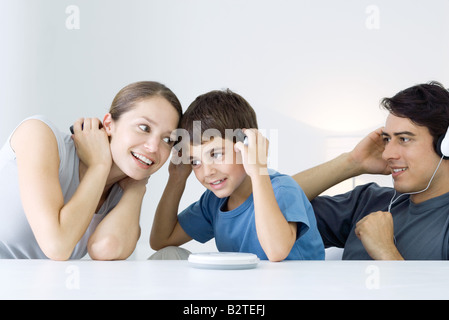 Famiglia ascolto di CD player insieme, madre e figlio condividendo le cuffie Foto Stock