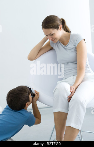 Little Boy fotografare sua madre con la fotocamera Foto Stock