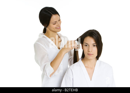 Hair stylist pettinatura donna capelli, sia cercando di distanza Foto Stock