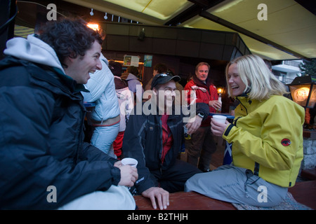 Un gruppo di giovani che godono di un Apres Ski party sulla terrazza del Papperla Pub, Zermatt, Vallese, Svizzera Foto Stock