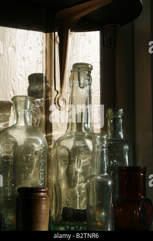 Vecchia collezione di bottiglie di casa sul davanzale Foto Stock