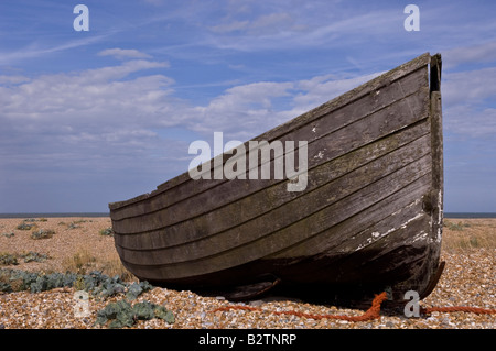 Un decadimento barca da pesca marciscono sulla spiaggia di ciottoli a Dungeness nel Kent Foto Stock