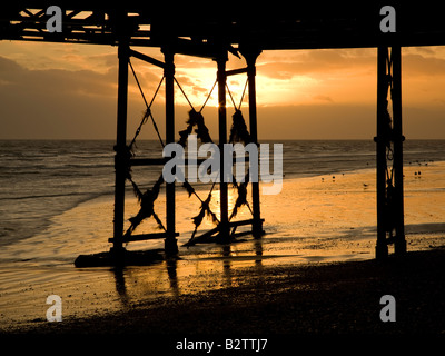 Tramonto dietro il molo, Worthing, West Sussex, in Inghilterra, Regno Unito Foto Stock