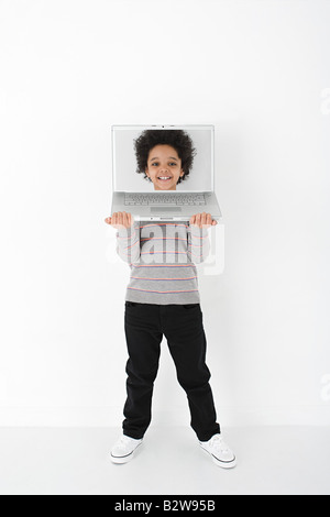 Ragazzo con la faccia sul computer portatile Foto Stock