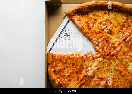 Una pizza e un calendario dicendo avviare la dieta Foto Stock