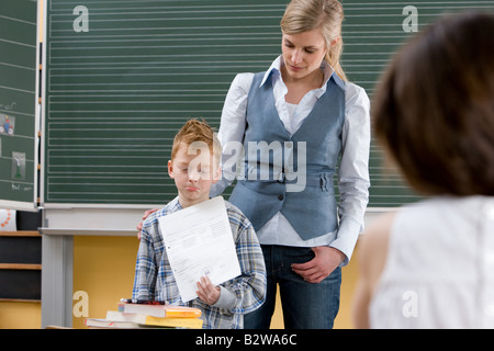 Ragazzo che guarda triste in aula Foto Stock