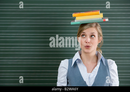 Insegnante con libri sulla sua testa Foto Stock