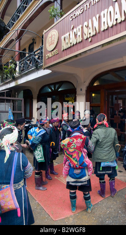 Nero hilltribe Hmong donne folla outswide Sapa alberghi spera di vendere ninnoli e mestieri Vietnam Foto Stock