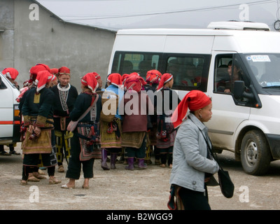 Red Dzao hilltribe donne clamore intorno i turisti e i bus turistici a vendere artigianato Ta Phin villaggio nei pressi di Sapa Vietnam Foto Stock