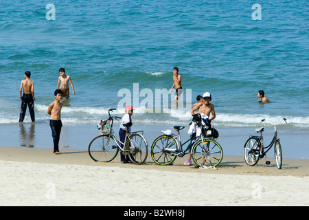 Giovani uomini vietnamita la balneazione in Cina spiaggia vicino Danang che è sinonimo di noi ABC fiction TV serie Vietnam Foto Stock