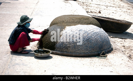 Donna guarnizioni circolari tradizionali tessuti barche coracle Cham isola storica Hoi An Vietnam Foto Stock