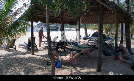 Ai visitatori di rilassarsi in amache sulla sabbia bianca Chong Beach Cham isola storica Hoi An Vietnam Foto Stock