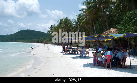 I visitatori di mangiare e bere in ombra di ombrelloni sabbia bianca Bai Sao beach south east Phu Quoc Island in Vietnam Foto Stock