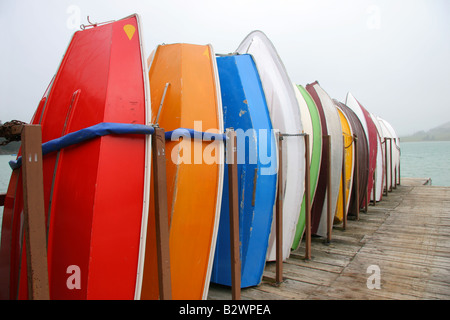 Multi-colore di gommoni barche impilati in una fila sul molo del porto di Diamante, sulla Penisola di Banks, vicino a Christchurch, Nuova Zelanda Foto Stock