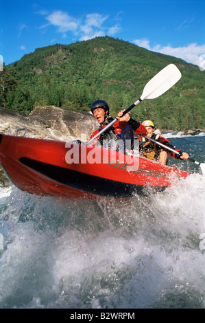 Due kayakers canottaggio in rapids (messa a fuoco selettiva) Foto Stock