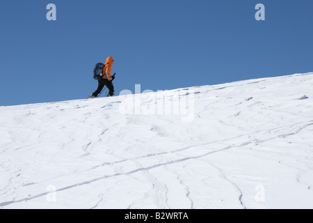 Uno sciatore attraversa il vento spazzate fuori pista in Via Lattea ski area di Sauze d'Oulx, Italia settentrionale Foto Stock