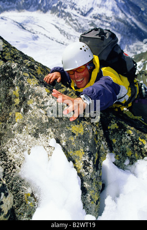 L'alpinista coming up montagna innevata sorridente (messa a fuoco selettiva) Foto Stock