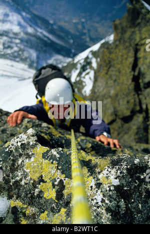 L'alpinista coming up montagna innevata sorridente (messa a fuoco selettiva) Foto Stock