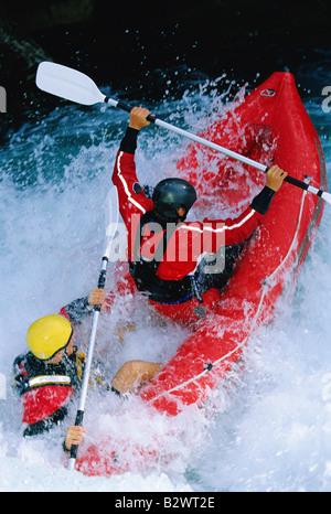 Due kayakers canottaggio in rapids (messa a fuoco selettiva) Foto Stock