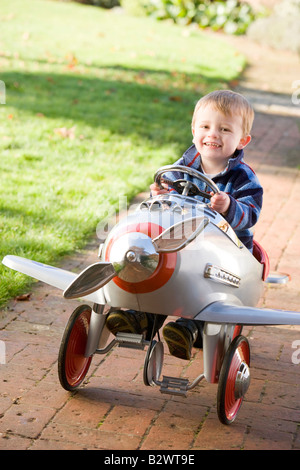 Giovane ragazzo giocando all'aperto in aereo sorridente Foto Stock