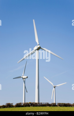 Tre turbine eoliche generatori di energia elettrica per la generazione di potenza su un centrali eoliche onshore contro il cielo blu su rurale isola di Anglesey North Wales UK Foto Stock