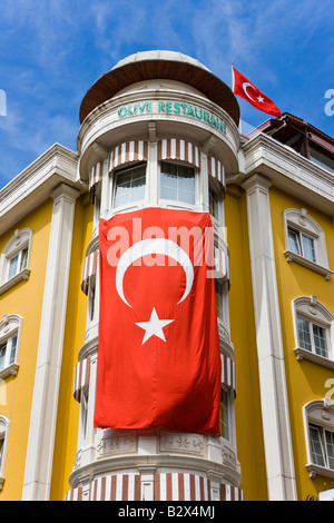 Il bagno turco bandiera nazionale pendente da un edificio giallo a Sultanahmet, Istanbul Turchia Foto Stock