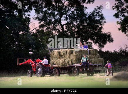 Una famiglia contadina raccolta di fieno in stile tradizionale nel GLOUCESTERSHIRE REGNO UNITO Foto Stock