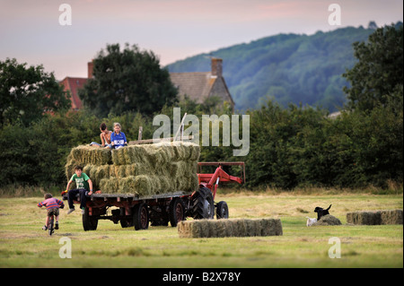 Una famiglia contadina raccolta di fieno in stile tradizionale nel GLOUCESTERSHIRE REGNO UNITO Foto Stock