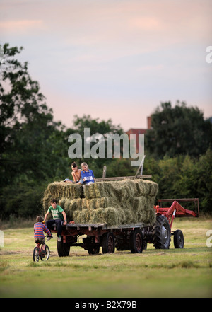 Una famiglia contadina raccolta di fieno in stile tradizionale nel GLOUCESTERSHIRE REGNO UNITO Foto Stock