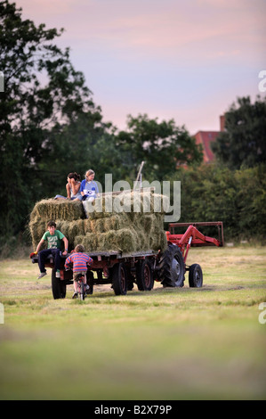 Una famiglia contadina raccolta di fieno in stile tradizionale nel GLOUCESTERSHIRE REGNO UNITO Foto Stock