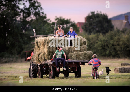 Una famiglia contadina raccolta di fieno in stile tradizionale nel GLOUCESTERSHIRE REGNO UNITO Foto Stock