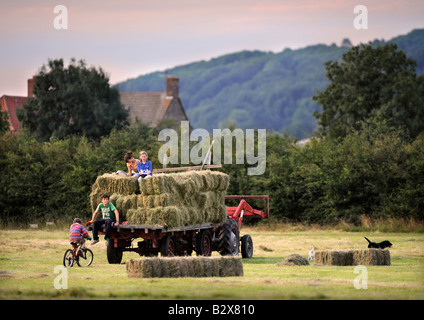 Una famiglia contadina raccolta di fieno in stile tradizionale nel GLOUCESTERSHIRE REGNO UNITO Foto Stock