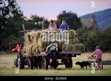 Una famiglia contadina raccolta di fieno in stile tradizionale nel GLOUCESTERSHIRE REGNO UNITO Foto Stock