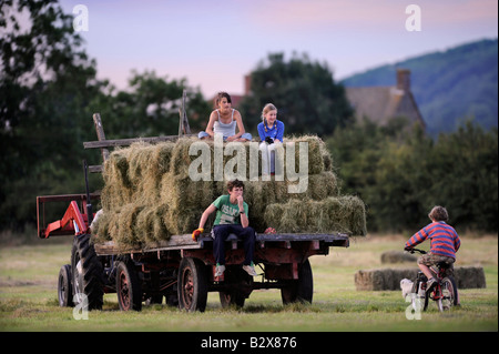 Una famiglia di agricoltori di ritornare a casa dopo la fienagione nello stile tradizionale nel GLOUCESTERSHIRE REGNO UNITO Foto Stock