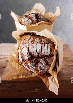 Pani di pane di Rye artigianale in un ambiente rustico su un tavolo di legno Foto Stock