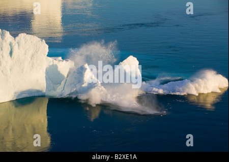 Un iceberg arcuata collassare in mare dal ghiacciaio Jacobshavn o Sermeq Kujalleq che drena il 7% del ghiaccio della Groenlandia Foto Stock