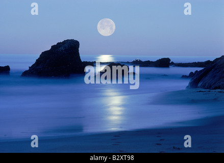 Impostazione della luna sulla spiaggia rocciosa lungo la costa del Pacifico in Laguna Beach in California Foto Stock
