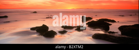 Cielo di tramonto pittura rocce e riva sabbiosa in Laguna Beach in California Foto Stock