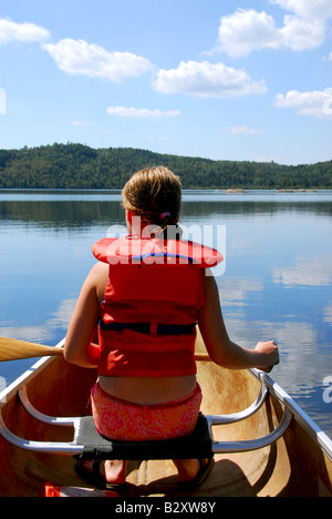 Bambino in canoa kayak su un pittoresco lago Foto Stock